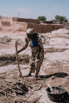 African woman engaging in traditional farming practices in rural Nigeria.